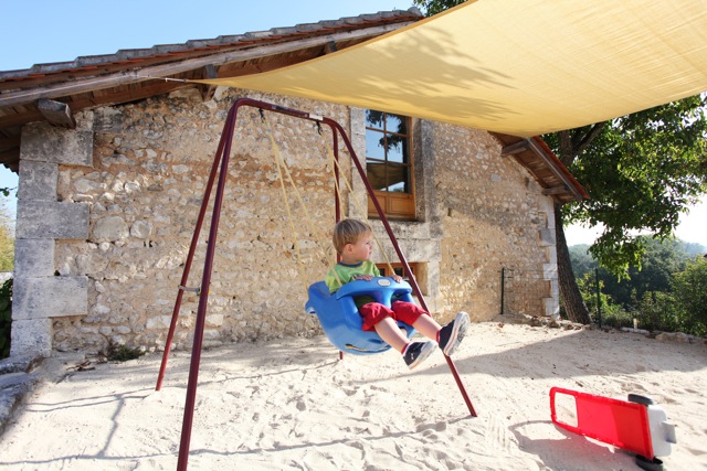 Sandpit swing, toddler playing on holiday in France